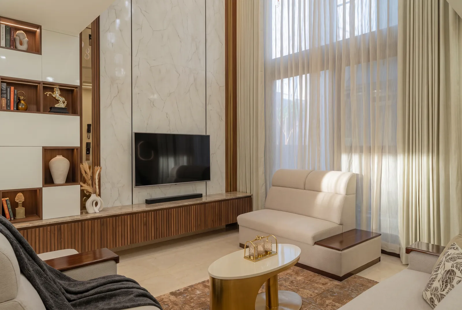 A double-height living room with a marble TV wall, smoked-oak display shelves and a fluted walnut console.