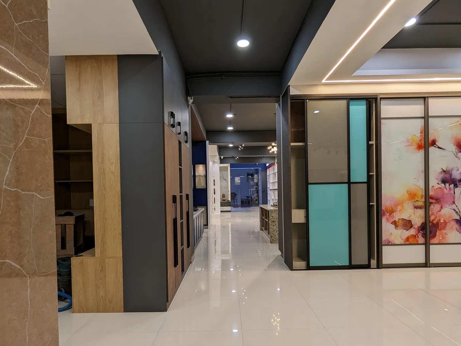Inside the Bangalore experience centre: a long, bright corridor lined with kitchen and wardrobe displays.